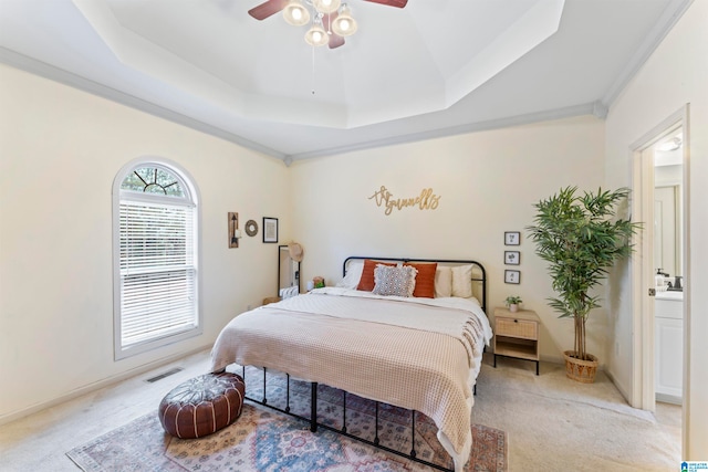 carpeted bedroom featuring ceiling fan, crown molding, and a tray ceiling