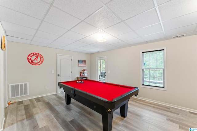 game room featuring wood-type flooring, a healthy amount of sunlight, and a drop ceiling