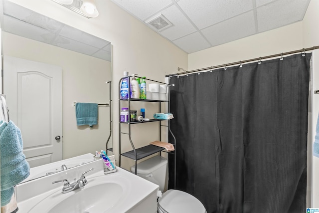 bathroom featuring a paneled ceiling, toilet, vanity, and a shower with shower curtain