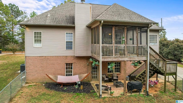 back of property with a patio area, central air condition unit, a sunroom, and a yard