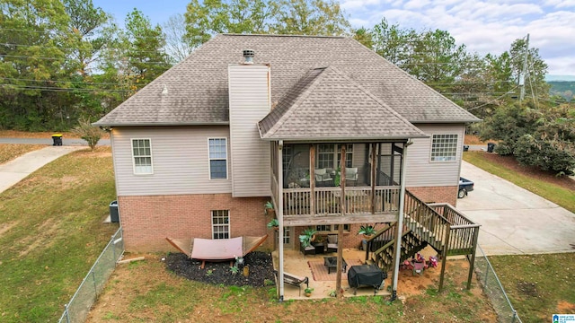 back of property featuring a patio area, a sunroom, and a lawn