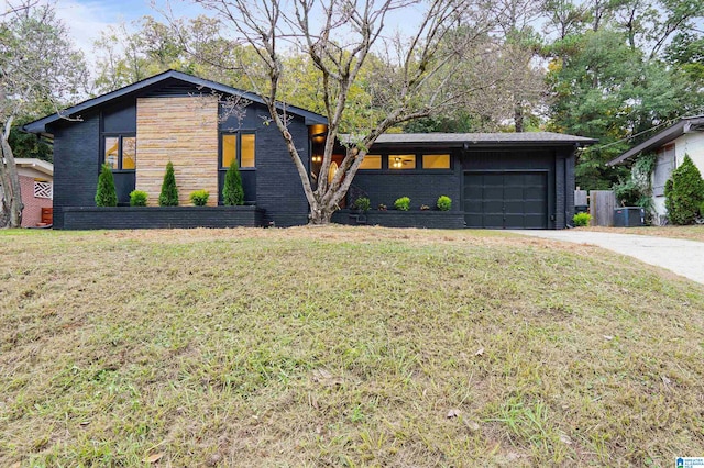 contemporary house with a garage, central AC, and a front lawn