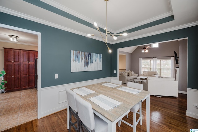 dining space with ceiling fan with notable chandelier, hardwood / wood-style flooring, and crown molding