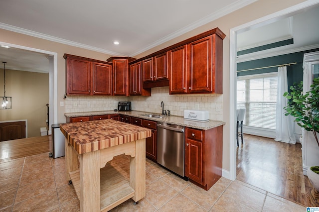 kitchen with ornamental molding, light wood-type flooring, decorative light fixtures, sink, and stainless steel dishwasher