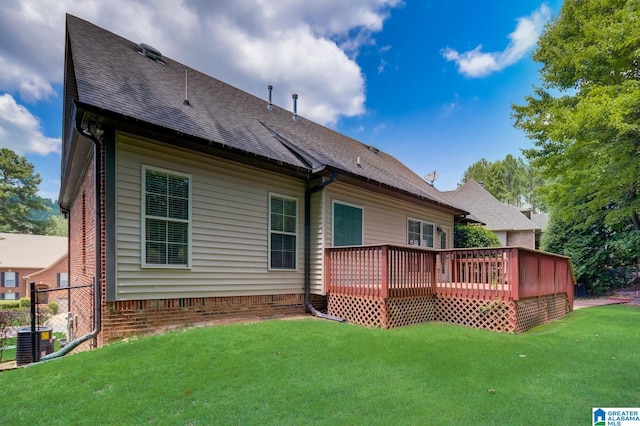 back of house featuring a lawn and a deck