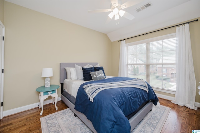 bedroom featuring hardwood / wood-style flooring, ceiling fan, multiple windows, and vaulted ceiling