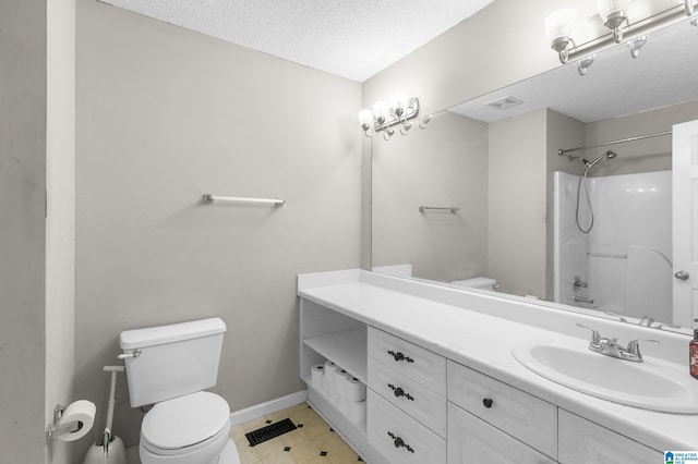 bathroom featuring toilet, vanity, and a textured ceiling