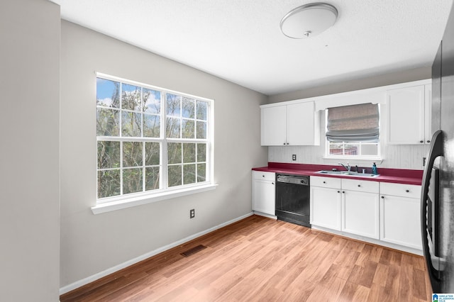 kitchen with sink, white cabinets, stainless steel fridge, light wood-type flooring, and black dishwasher