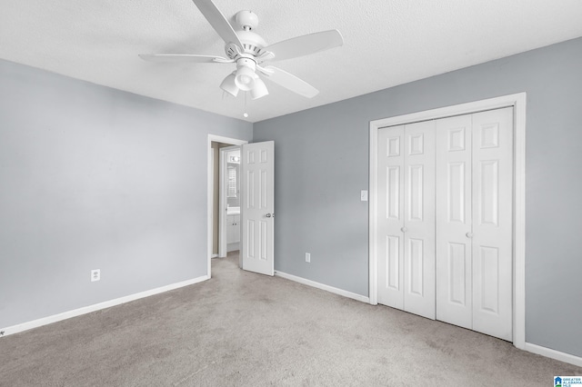 unfurnished bedroom featuring a textured ceiling, light colored carpet, ceiling fan, and a closet