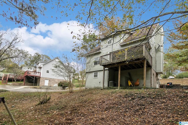 back of house with central air condition unit and a wooden deck