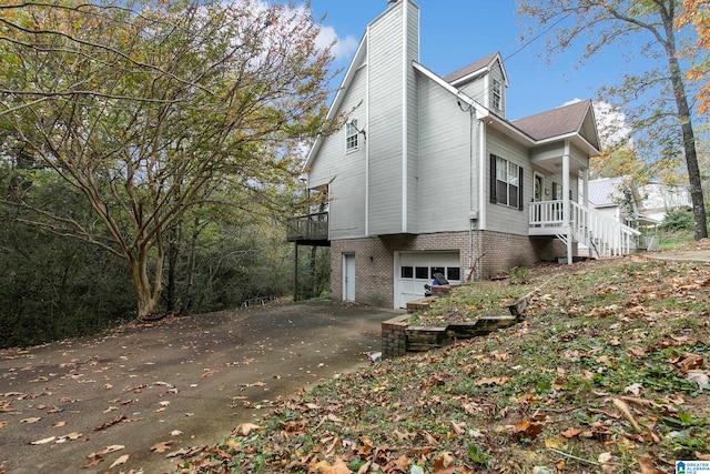 view of side of property with a garage and covered porch