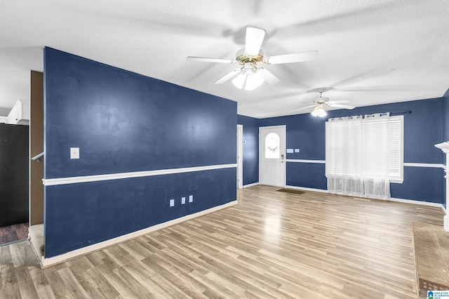 unfurnished room featuring light wood-type flooring, a textured ceiling, and ceiling fan