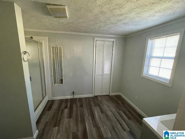 unfurnished bedroom with a textured ceiling, a closet, and dark wood-type flooring