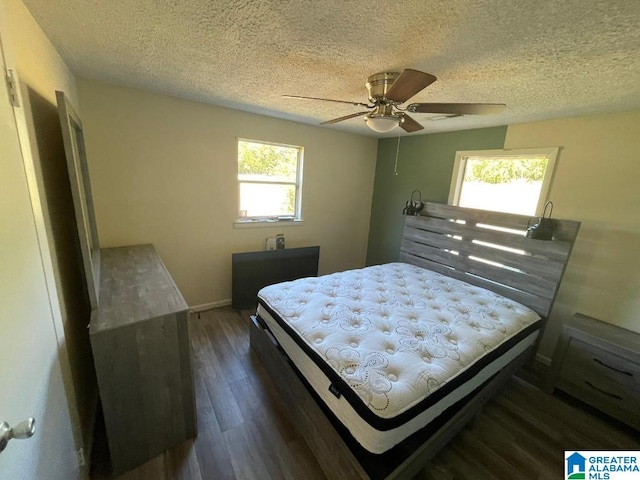 bedroom with a textured ceiling, ceiling fan, and dark hardwood / wood-style floors