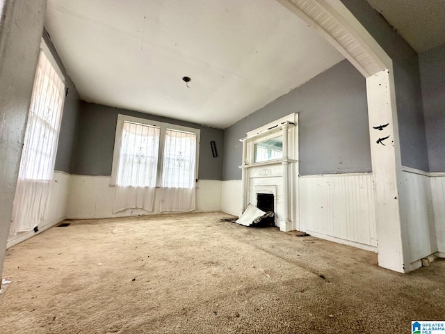 unfurnished living room with light carpet and vaulted ceiling