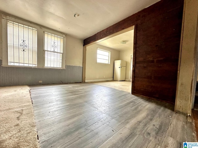 interior space featuring wooden walls, hardwood / wood-style floors, and beam ceiling