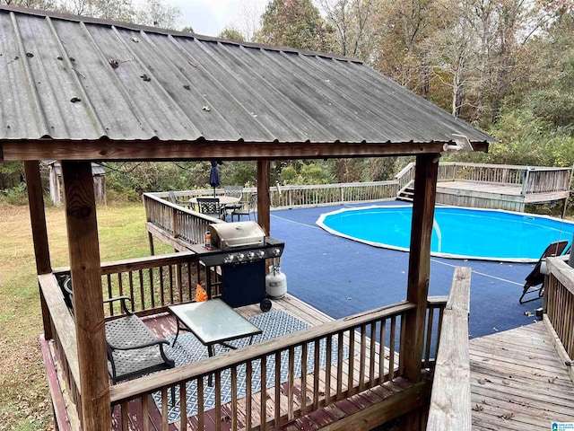 view of pool with area for grilling and a wooden deck