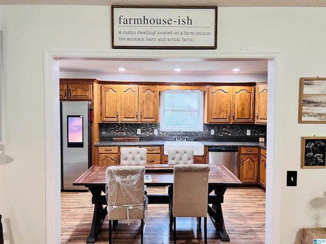 kitchen featuring decorative backsplash, stainless steel appliances, and light hardwood / wood-style flooring