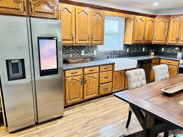 kitchen featuring light hardwood / wood-style floors, appliances with stainless steel finishes, sink, and backsplash