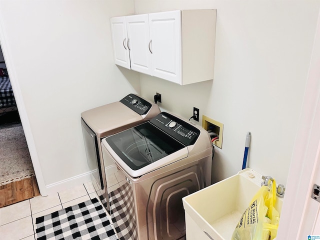 laundry area featuring light tile patterned floors, washer and dryer, sink, and cabinets