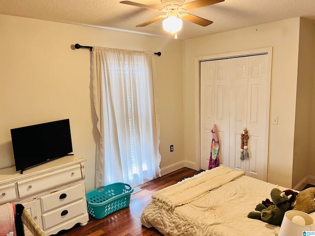 bedroom featuring a textured ceiling, multiple windows, dark wood-type flooring, and ceiling fan