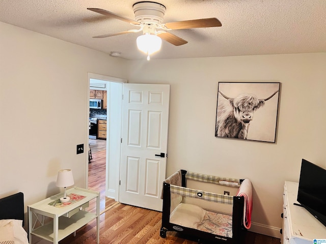 interior space featuring a textured ceiling, hardwood / wood-style floors, and ceiling fan