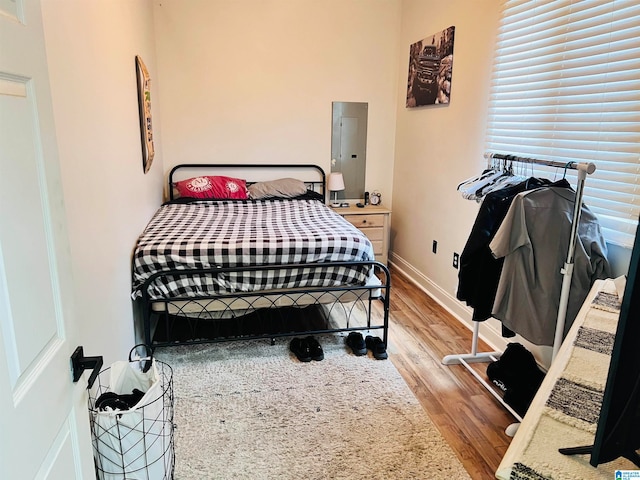 bedroom featuring electric panel and light hardwood / wood-style flooring