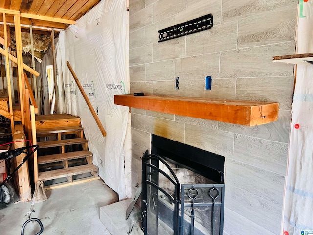 room details featuring a tiled fireplace and concrete floors