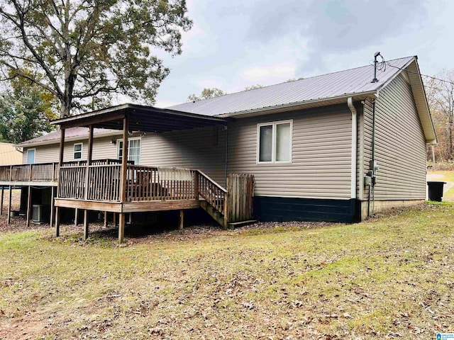 back of property featuring a lawn and a wooden deck