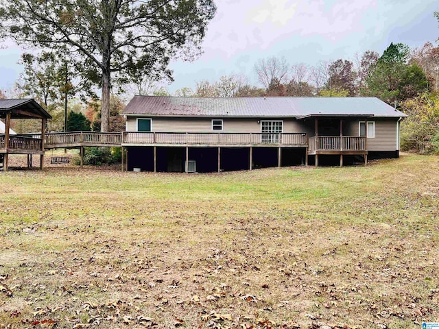 rear view of house featuring a lawn and a wooden deck