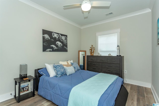 bedroom featuring hardwood / wood-style flooring, ceiling fan, and ornamental molding