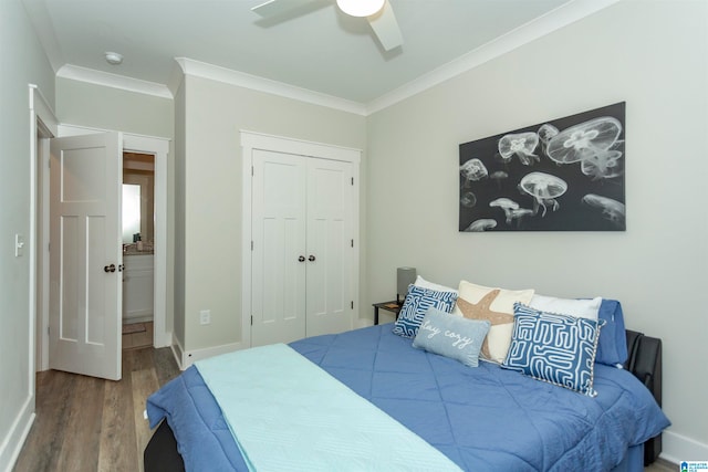 bedroom featuring hardwood / wood-style floors, ceiling fan, crown molding, and a closet