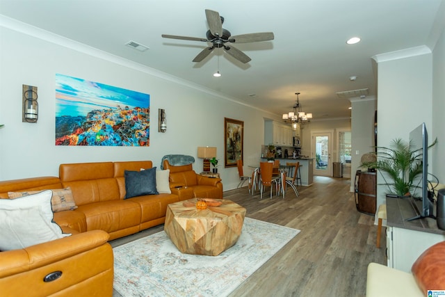 living room featuring ceiling fan with notable chandelier, hardwood / wood-style flooring, and crown molding