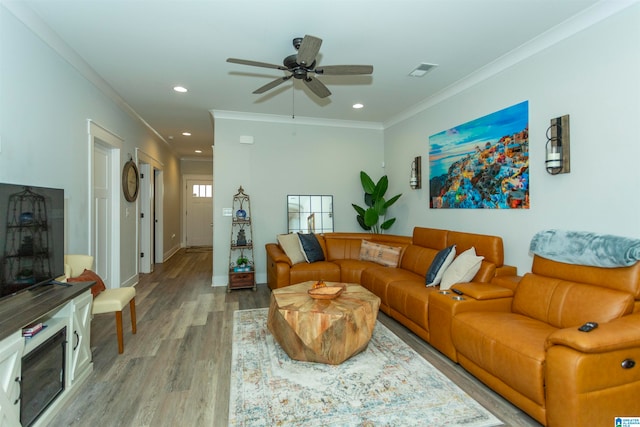 living room with ceiling fan, ornamental molding, and light hardwood / wood-style flooring