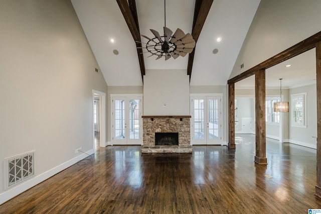 unfurnished living room with french doors, a healthy amount of sunlight, and beam ceiling