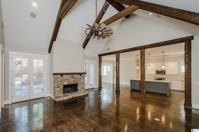 unfurnished living room featuring high vaulted ceiling, dark hardwood / wood-style floors, and french doors