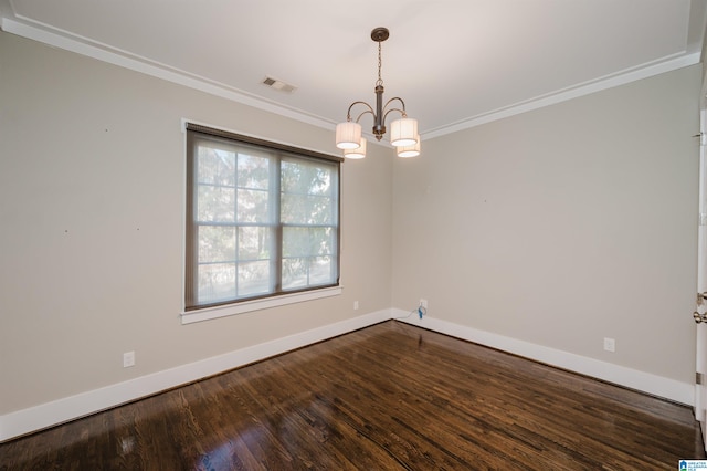 empty room featuring dark hardwood / wood-style flooring, an inviting chandelier, and ornamental molding