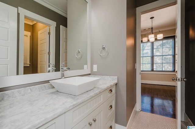 bathroom with hardwood / wood-style flooring, vanity, and crown molding