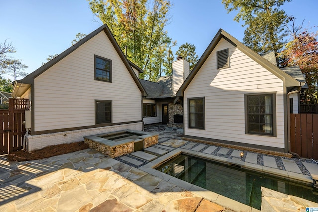 back of house featuring a pool and a patio area