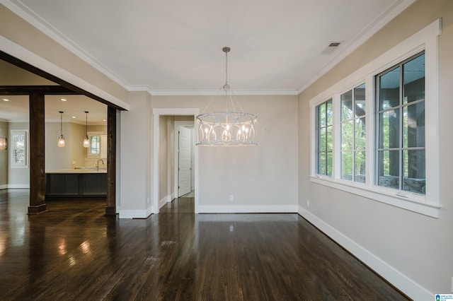 unfurnished dining area featuring dark hardwood / wood-style floors, crown molding, sink, and an inviting chandelier