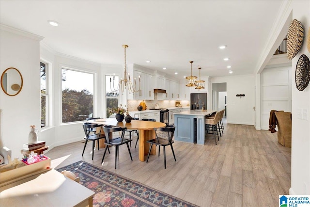 dining space with light wood-type flooring and crown molding