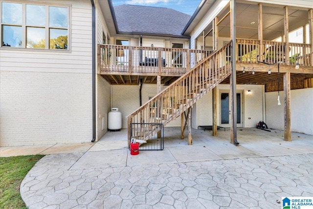 back of house featuring a deck and a patio