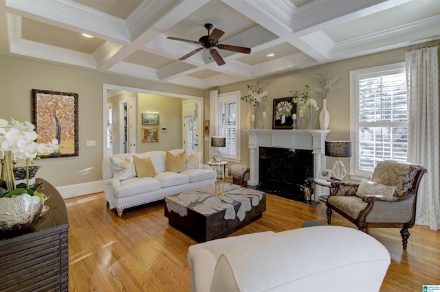 living room featuring light hardwood / wood-style floors, beamed ceiling, ceiling fan, crown molding, and coffered ceiling