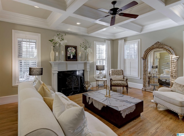 living room featuring light hardwood / wood-style floors, beamed ceiling, a healthy amount of sunlight, and a high end fireplace