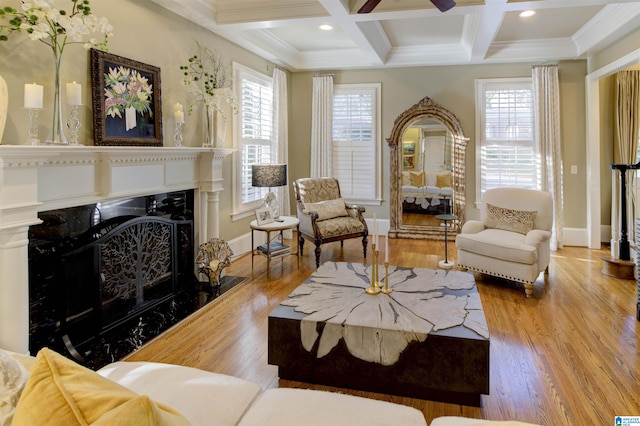 living room with ornamental molding, a fireplace, light wood-type flooring, beam ceiling, and coffered ceiling