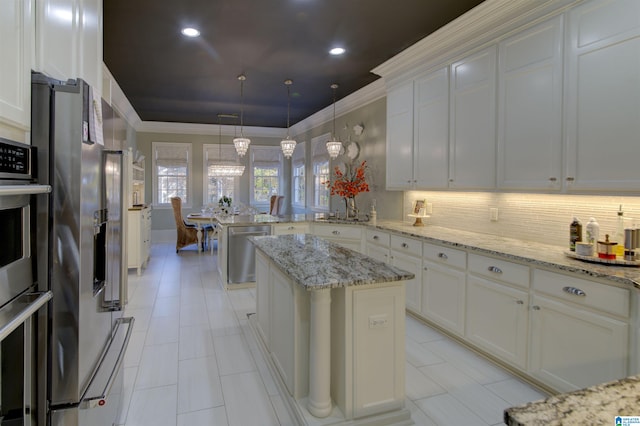 kitchen featuring a kitchen island, hanging light fixtures, light stone counters, and stainless steel appliances