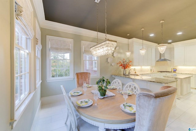 dining space with a notable chandelier, light tile patterned flooring, crown molding, and sink