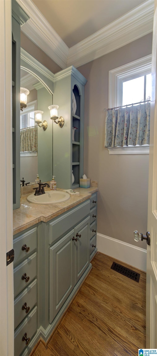 bathroom with hardwood / wood-style floors, vanity, and ornamental molding