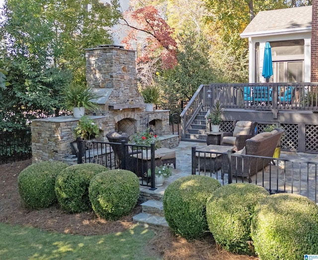 view of yard featuring a deck, a patio area, and an outdoor stone fireplace