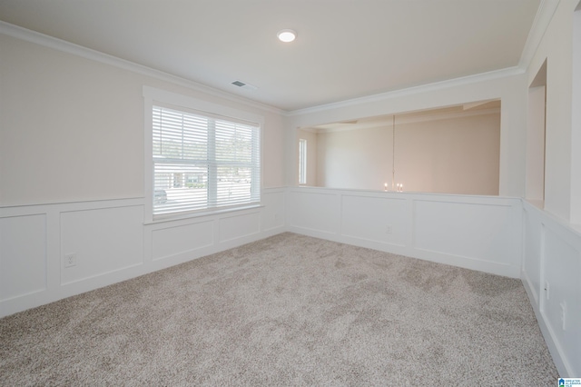 carpeted spare room featuring a chandelier and crown molding